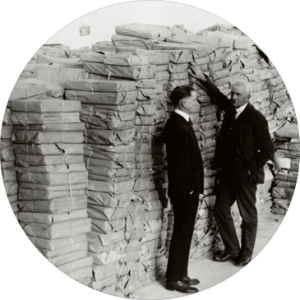 Professor Adams standing beside massive packages of documents removed by Hoover and transported to the west coast of America. 